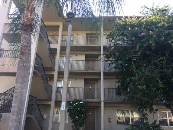 Front view of a multi-story apartment building with balconies.