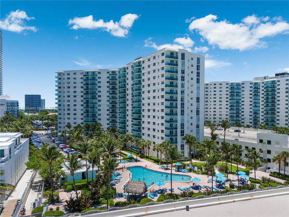 View of modern high-rise apartment buildings with balconies and a swimming pool area.