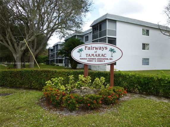 Front view of a multi-story condominium building with a sign that reads 'Fairways of Tamarac.'