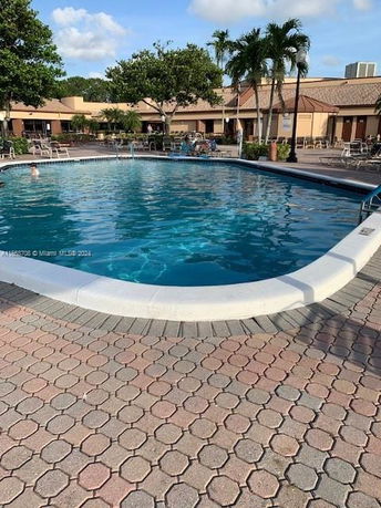 Outdoor swimming pool with surrounding patio area and trees.