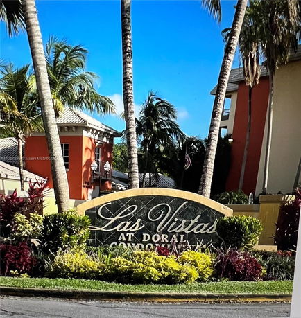 Front view of residential buildings with a sign that reads 'Las Vistas at Doral Condominiums'.