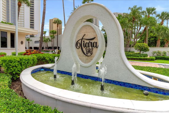 Front view of a building with a decorative fountain and sign.