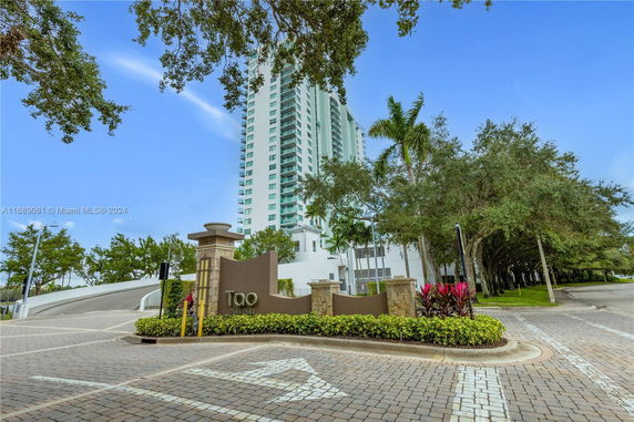 Front view of a tall residential building with multiple balconies.