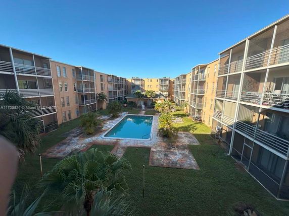 Outdoor view of a residential complex with a central swimming pool.