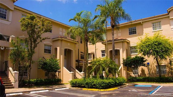 Front view of a multi-story apartment building with stucco exterior.