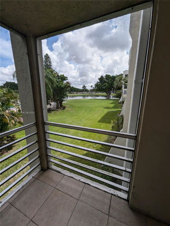 View of a grassy area and a pond, as seen from a balcony.