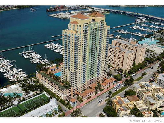 Front view of a high-rise residential building near a marina.