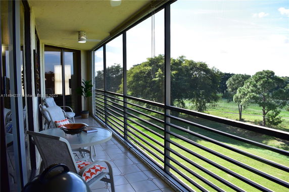 Balcony view overlooking green landscape with trees.
