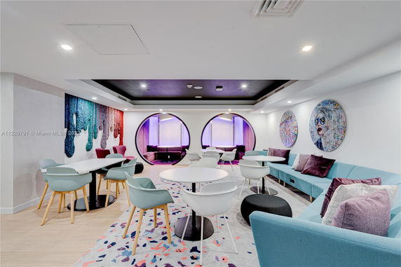 Interior view of a modern recreational area with colorful seating and circular wall designs.