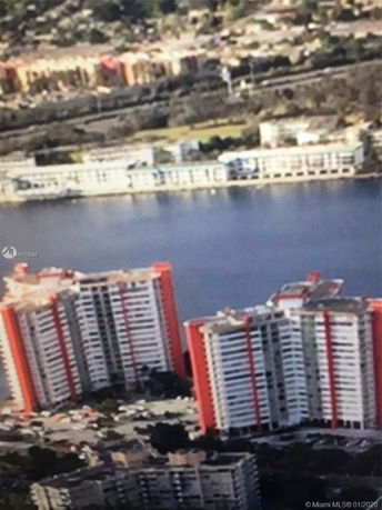 Aerial view of tall, multi-story apartment buildings near a body of water.