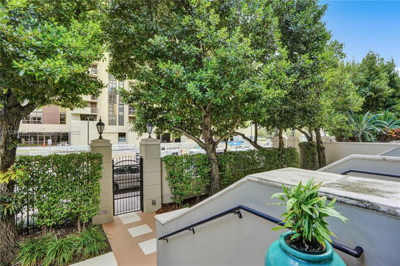 View of a building beyond a fenced patio and garden area.
