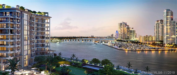 Panoramic view of waterfront buildings and a marina at dusk.