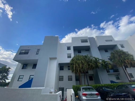 Front view of a modern multi-story building with geometric design elements and flat rooflines.