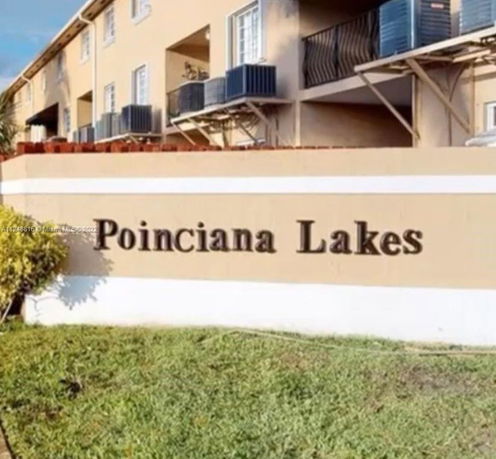 Front view of a multi-story apartment building with a sign reading 'Poinciana Lakes'.