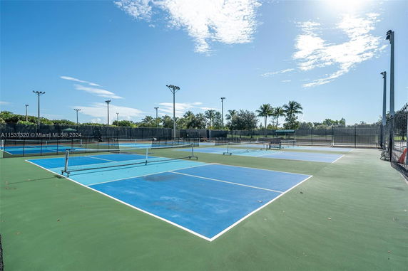 View of multiple outdoor tennis courts with surrounding fences.