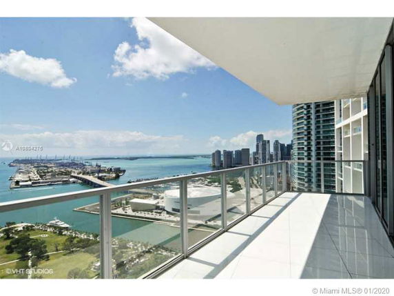 Wide angle view of city skyline and waterfront from a high-rise balcony.