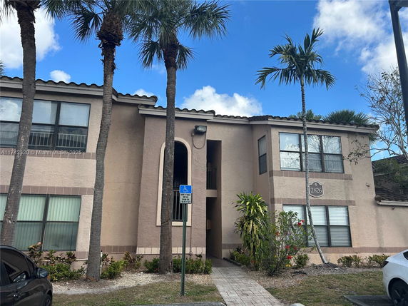 Front view of a two-story residential building with large windows.