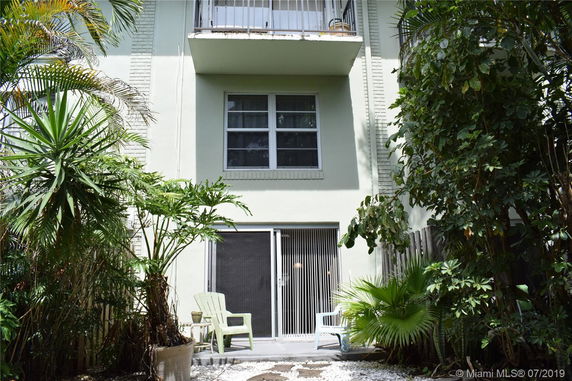 Front view of a two-story building with balcony and patio area.
