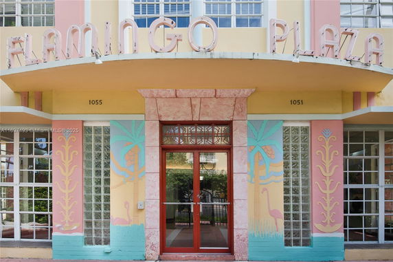 Front view of a building with pastel colors and art deco elements, named Flamingo Plaza.