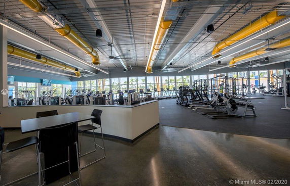 Interior view of a spacious gym with exercise equipment and seating area.