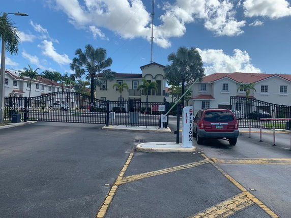 Front view of a gated residential complex with multiple two-story houses.