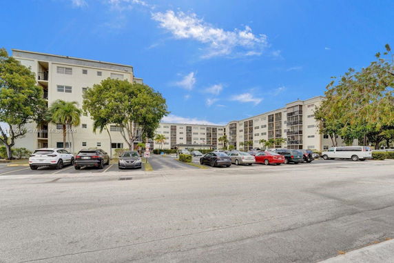 Outdoor parking area in front of a multi-story residential building.