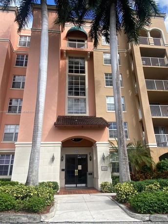 Front view of a multi-story residential building with balconies and a central entrance.
