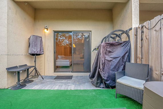 Outdoor area with patio furniture and sliding glass door leading to the interior.