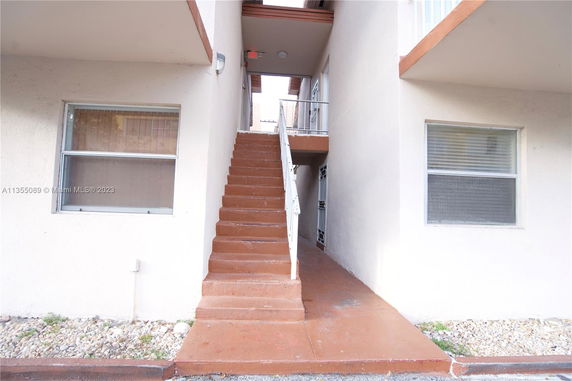 Front view of a building with an exterior staircase leading to the upper floor.
