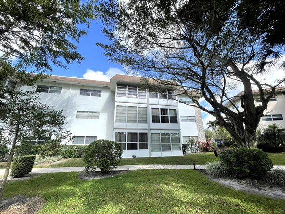 Front view of a multi-story residential building with several windows and a flat roof.