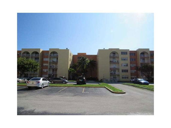 Front view of a multi-story apartment building with balconies.
