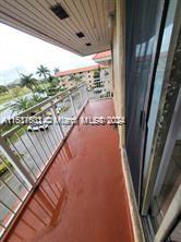 View from a balcony overlooking buildings and palm trees.
