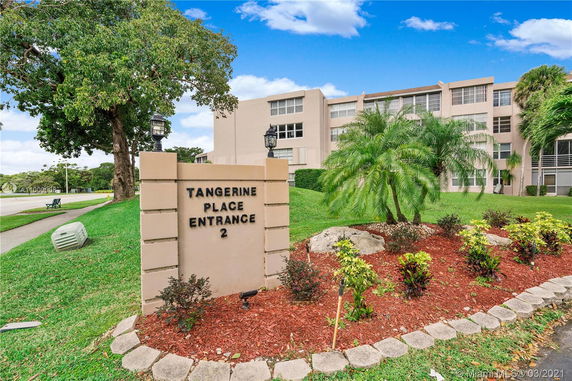 Front view of a multi-story building with a sign reading 'Tangerine Place Entrance 2'.