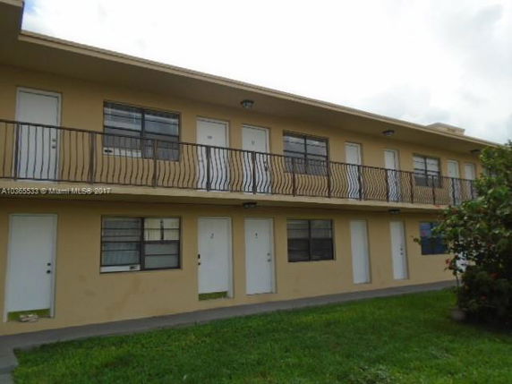 Front view of a two-story apartment building with balconies.
