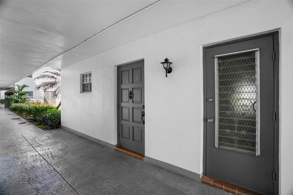 Exterior entrance view with two doors and a wall lamp