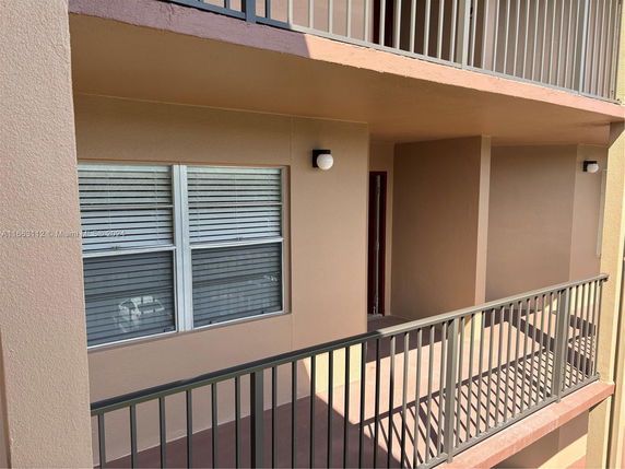 View of an apartment building exterior with a balcony and window.