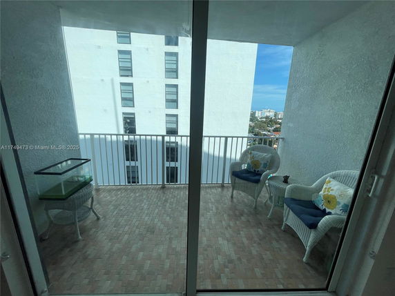 Balcony view from a high-rise building with seating area.
