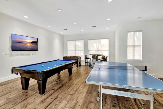Indoor recreational area with a pool table, ping pong table, and a wall-mounted television.