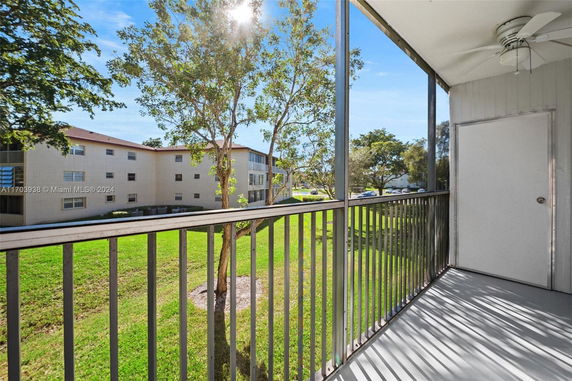View from a balcony showing nearby apartment complex and surrounding greenery.