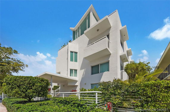 Front view of a multi-story modern building with balconies and large windows.