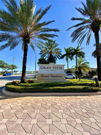 Entrance sign for Gran Vista at Doral Gardens with palm trees and paved walkway.