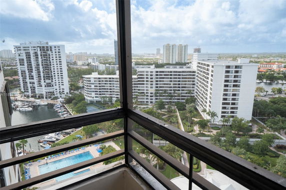 Panoramic view from a high-rise building balcony, overlooking a residential area with multiple surrounding buildings.