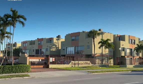 Front view of a multi-story building with gated entrance.