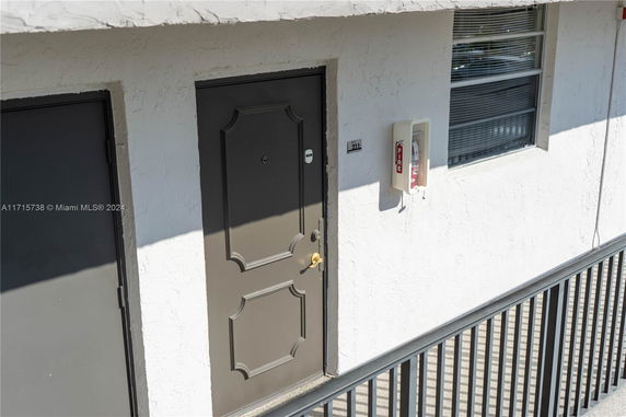 Exterior view of a building with a door and a fire extinguisher mounted on the wall.