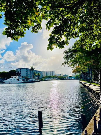 Scenic view of a waterfront area with buildings and a yacht.
