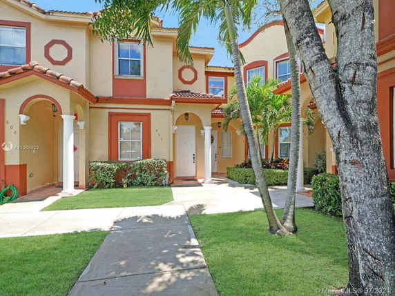 Front view of a two-story house with decorative arches and columns.