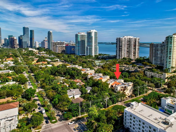 Panoramic view of a cityscape with buildings and a body of water in the background.