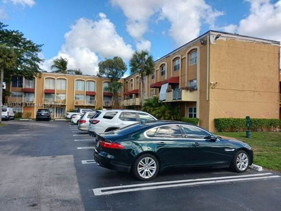 Parking area in front of a multi-story residential building.