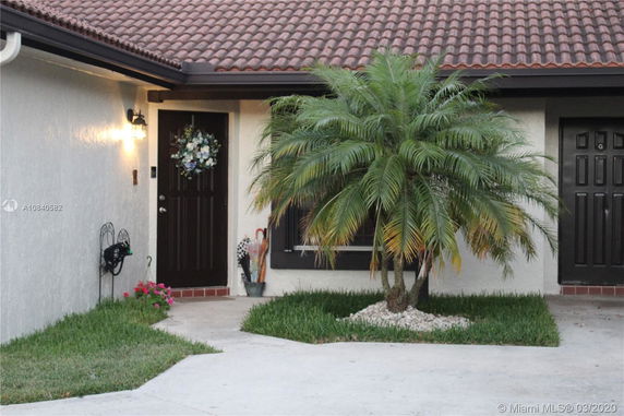 Front view of a house with a dark front door and tile roof.