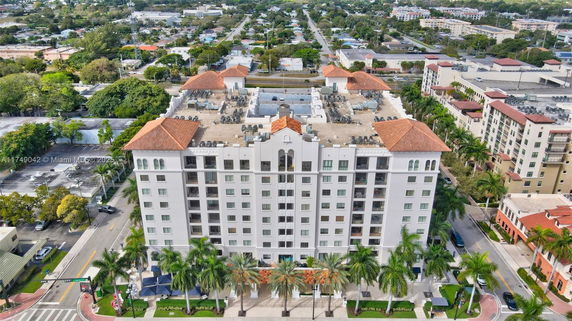 Front view of a multi-story apartment building with a symmetrical design and red-tiled roof.